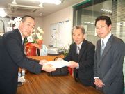 要請署名を渡す新山税金対策部長(中)