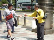 熱心にチラシ等を配る役員（右）