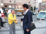 チラシを渡す新山税対部長（左）