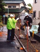 &nbsp;建設現場を訪問し組合の説明をする役員（左）