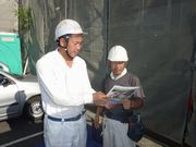 建築現場で組合員に組合のメリットを説明する野田支部長（左）