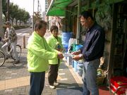 金物店にて店主に組合パンフレットを店頭に置いていただくように依頼する役員（左・中央）