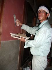 壁塗り作業をする佐野副部長