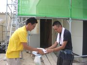 現場に訪問し、パンフを手渡す幹事（左）