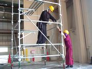 足場を組む作業をする村上さん（左）