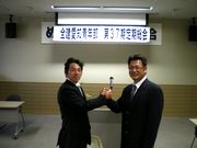 固い握手を交わす小泉前青年部長(左)と杉浦新青年部長(右)