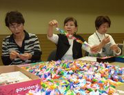 千羽鶴のつなぎ作業をする役員