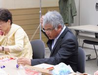 千羽鶴のつなぎ作業をする杉浦組織部長