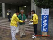 出入口で組合パンフを渡す役員（左右）