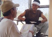 建築現場を訪問して、熱心に組合制度を説明する役員（左）