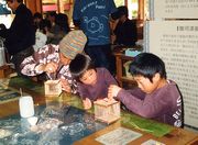 &nbsp;夢中になって虫かごを作る親子