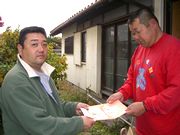 組合の資料を手渡す役員（左）