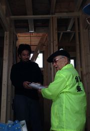 若い職人さんにパンフを渡す役員（右）