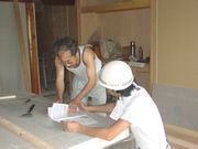 建築現場で、未加入者の方に声を掛ける役員さん（奥）