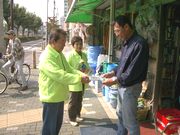 パンフ等を手渡す役員（左）