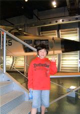 戦闘機の前でピース