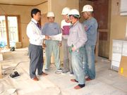 コンクールに応募予定の建築現場で、職人さんに作業の指示をする、冬頭さん（左）