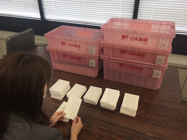 1枚1枚要請ハガキに目を通す厚生労働省職員