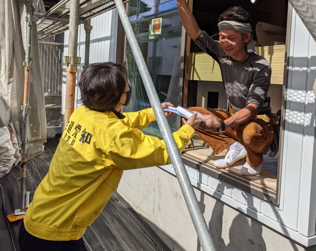 現場にいる職人さんへパンフを渡しています